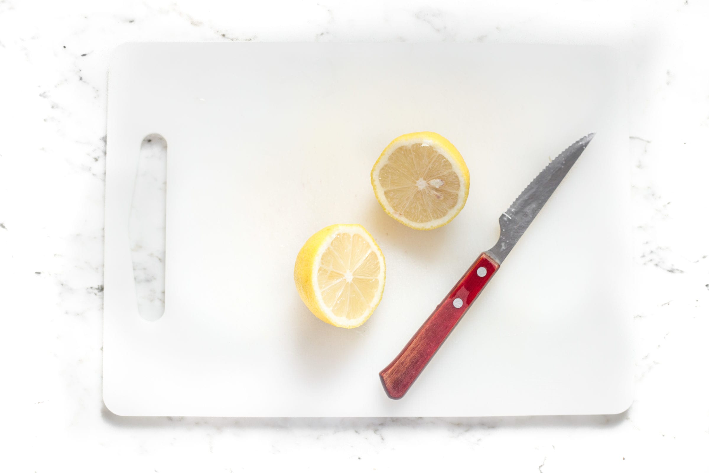 image of a lemon cut in half on cutting board