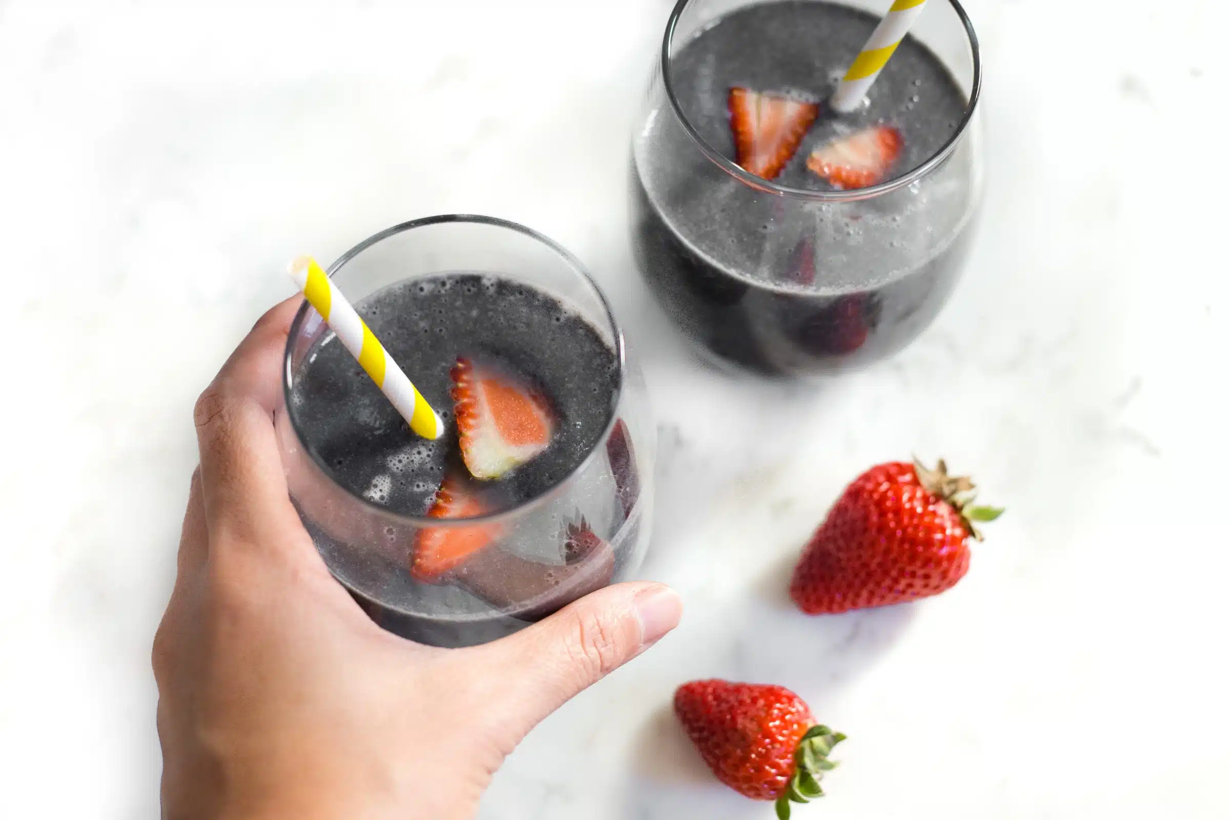 image of two glasses of activated charcoal smoothie with strawberries